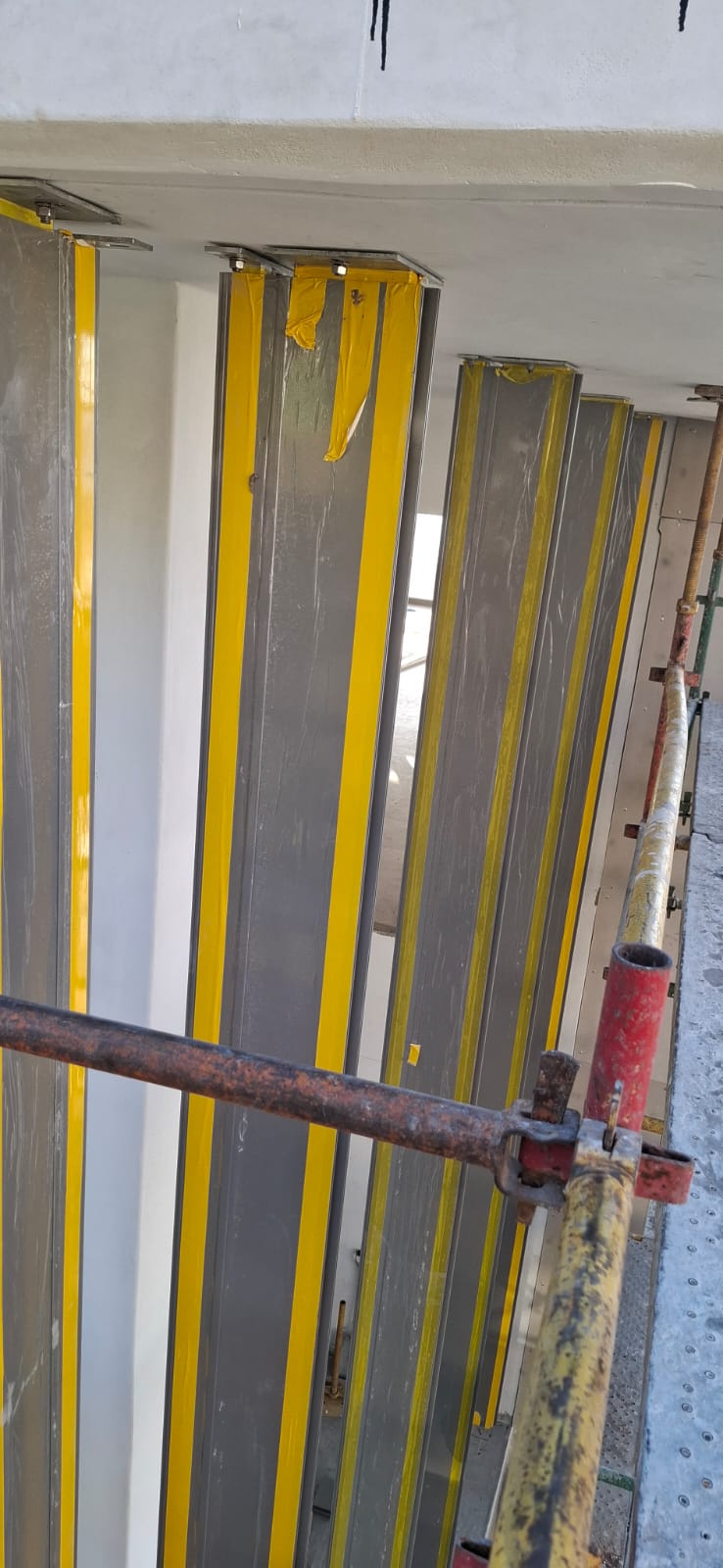 Tools and mounting brackets visible during the curtain wall glazing installation in Sea Point.