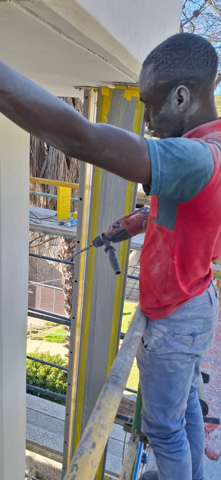 Close-up view of curtain wall installation showing workers fitting glass panels in Sea Point.