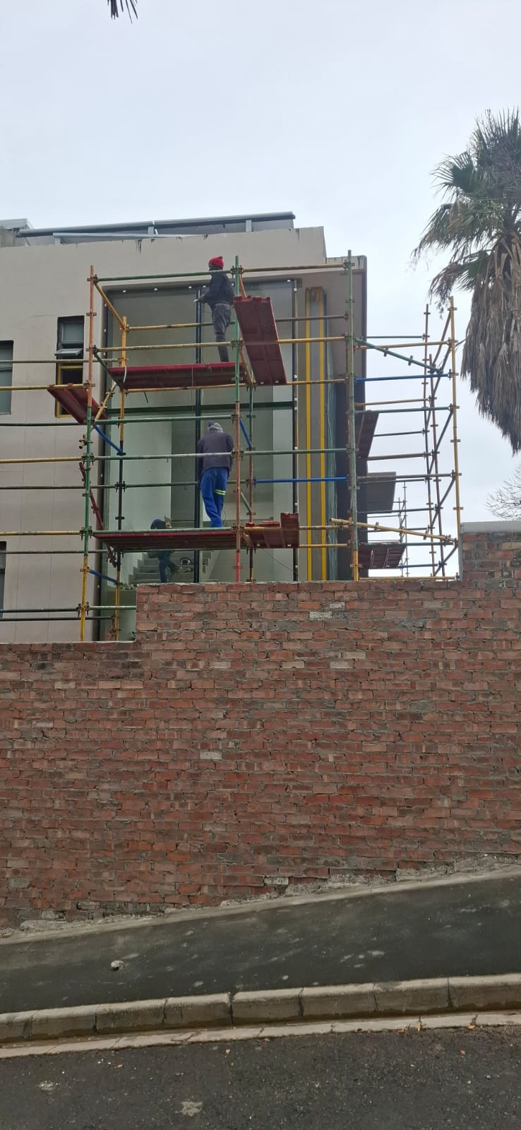 Tall building under construction in Sea Point with scaffolding during flush glazing installation.