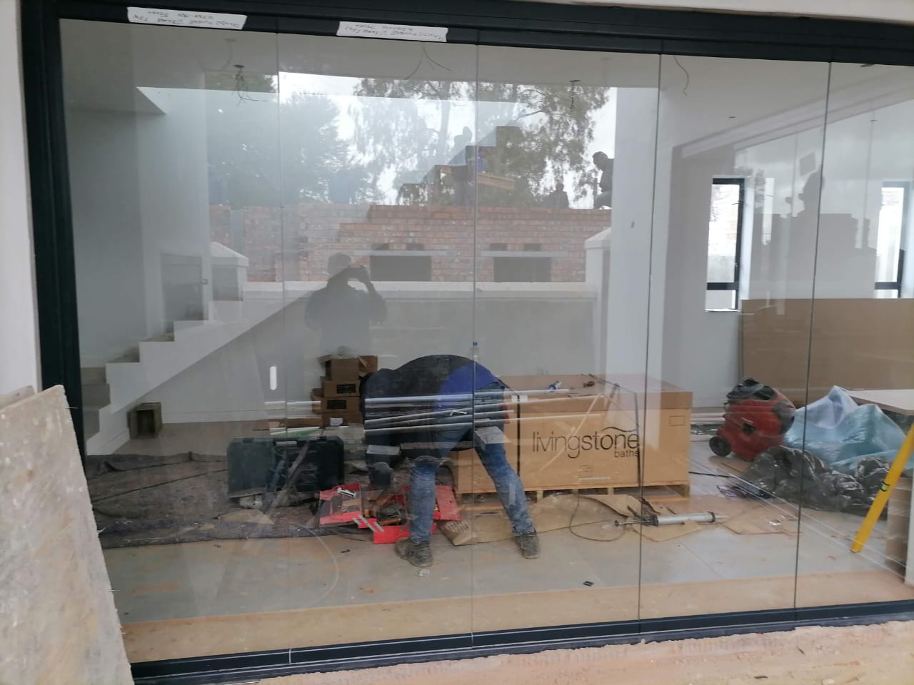 Large frameless glass sliding door system closed, forming a full glass wall in Cape Town.