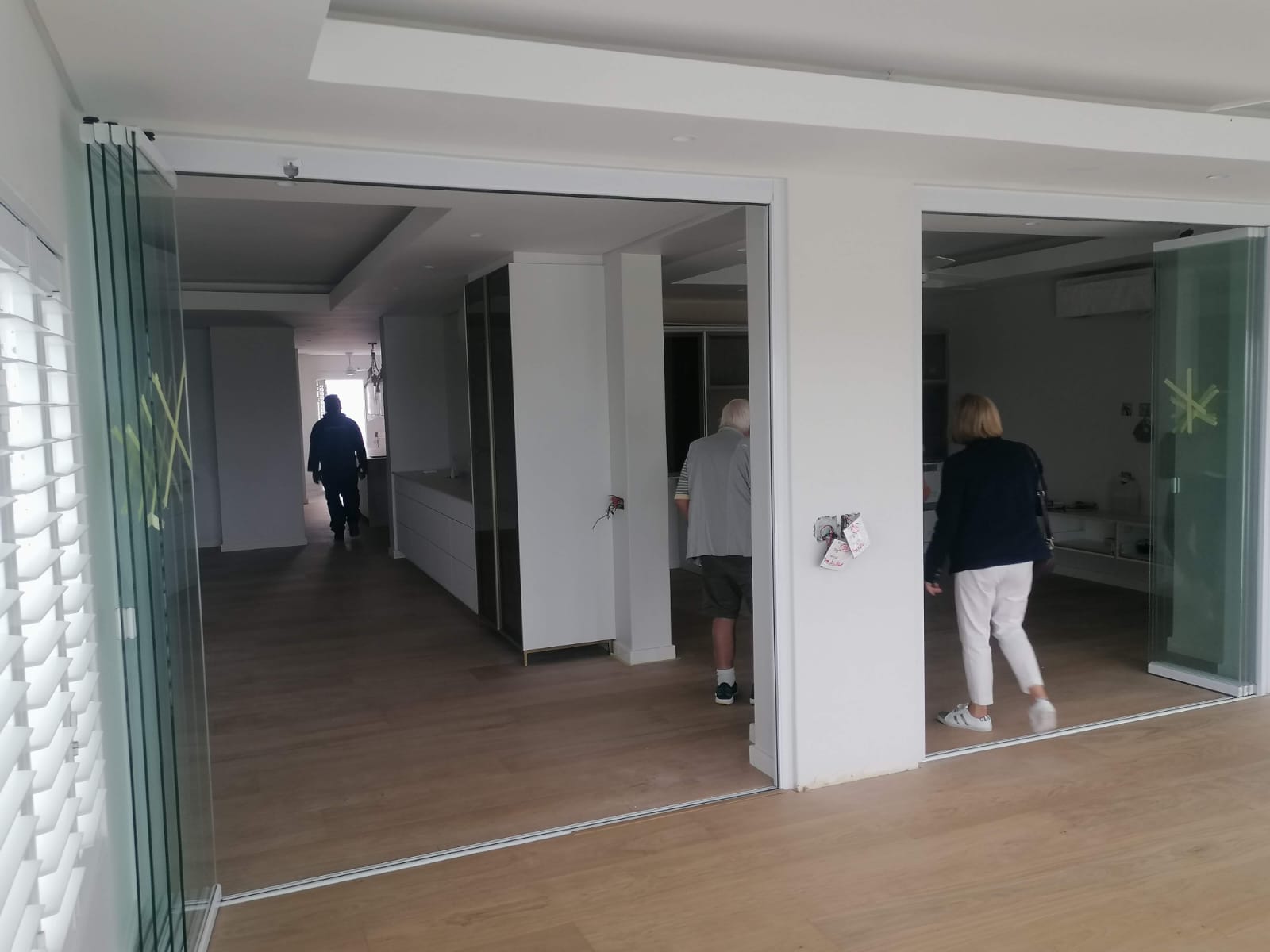 Large frameless sliding glass doors open and stacked along the wall in Cape Town.