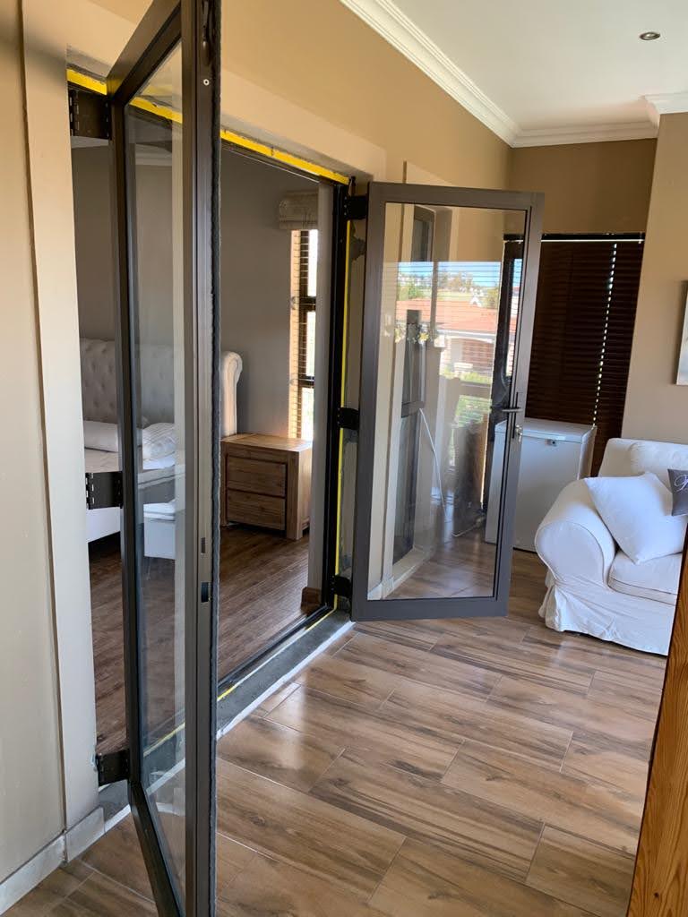 Side view showing open aluminium and glass sliding doors stacked along the wall in Durbanville.