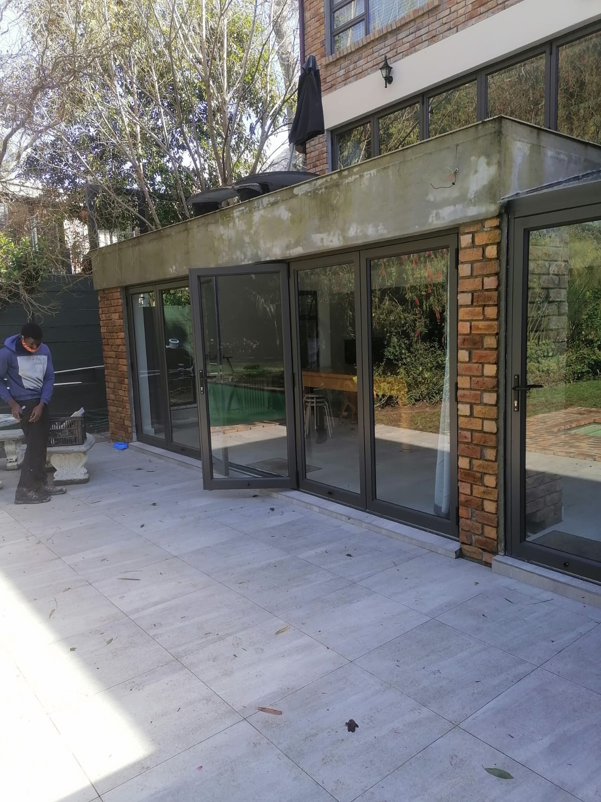 Front view of a double-storey house in Newlands featuring aluminium sliding and stacking doors.