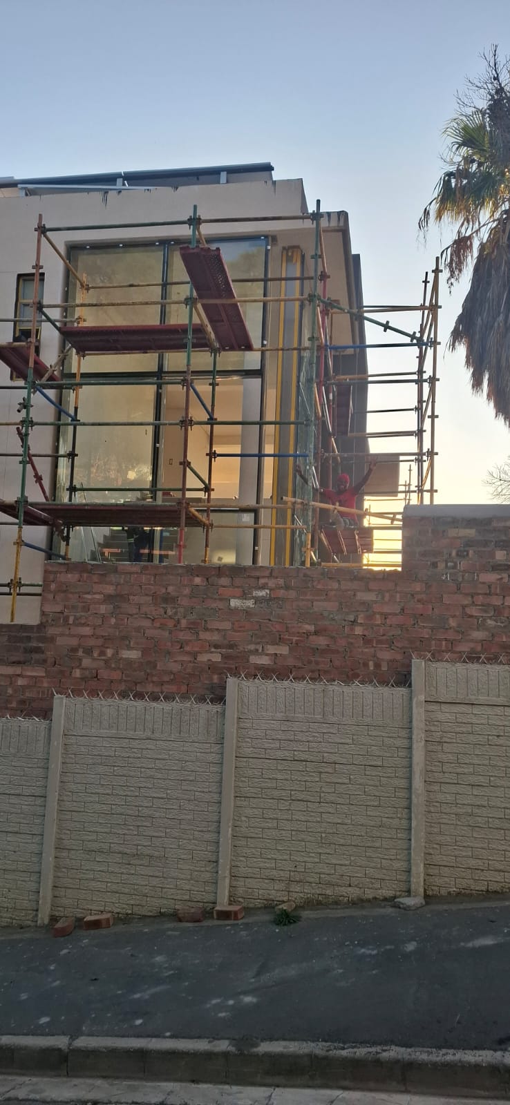 Wide view of tall building with scaffolding during façade glazing project in Sea Point.