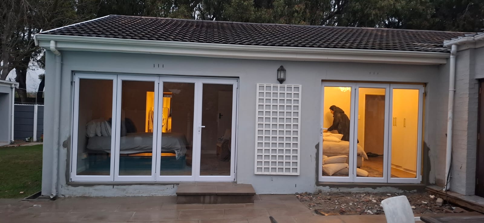 Front view of a house in Tokai featuring white aluminium four-panel and three-panel sliding folding doors.