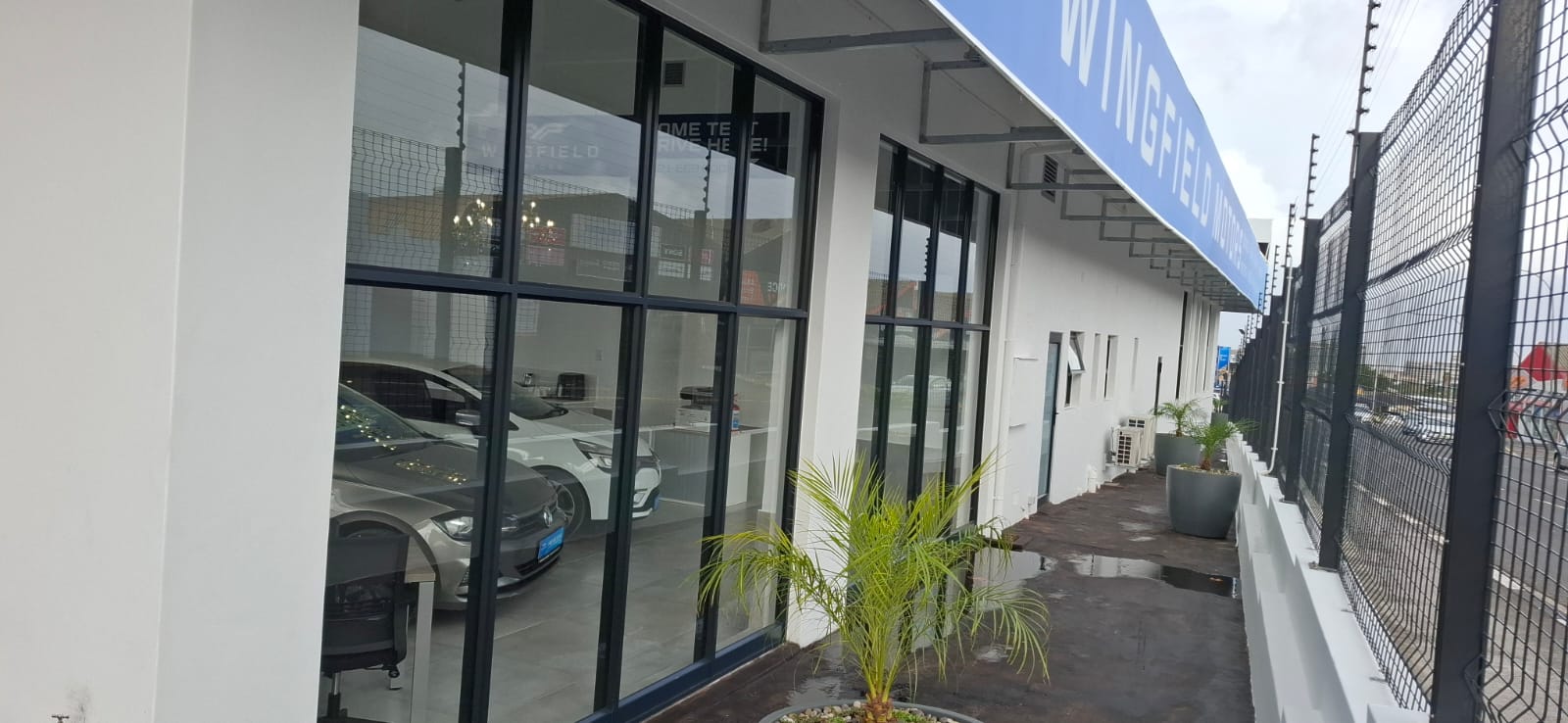 Side view of Wingfield Motors aluminium shopfront with bronze and black framing, Goodwood, Cape Town.