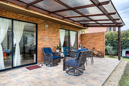 Inviting brick patio with wicker chairs and plants, perfect for relaxation.